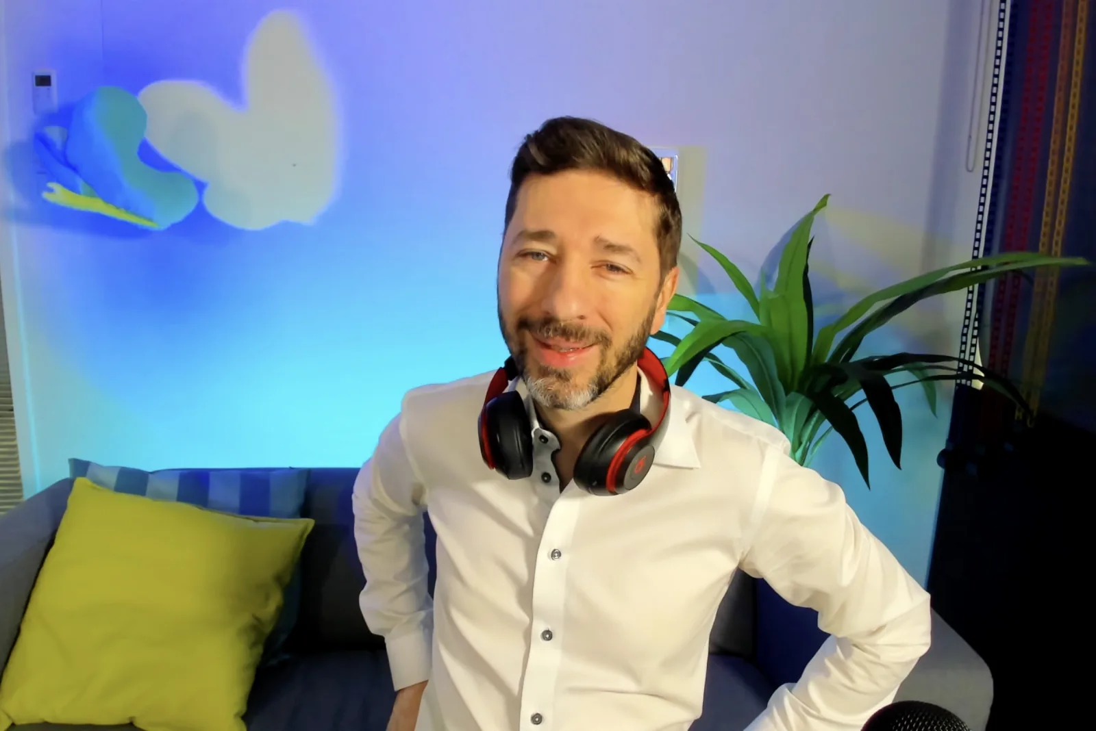 Eric Rousseau souriant, casque d'écoute au cou, dans un décor de conférence en ligne