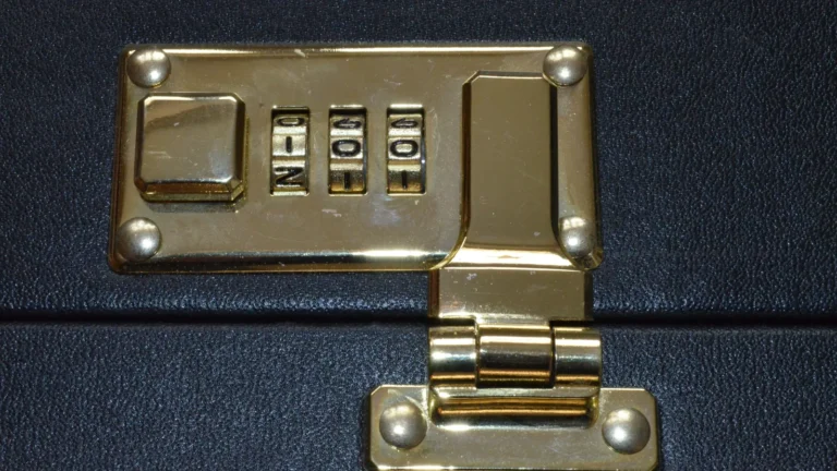 Cadenas à code en laiton doré à trois chiffres fixé sur une mallette de cuir noir