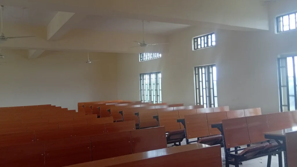Salle de classe vide avec pupitres en bois alignés et grandes fenêtres