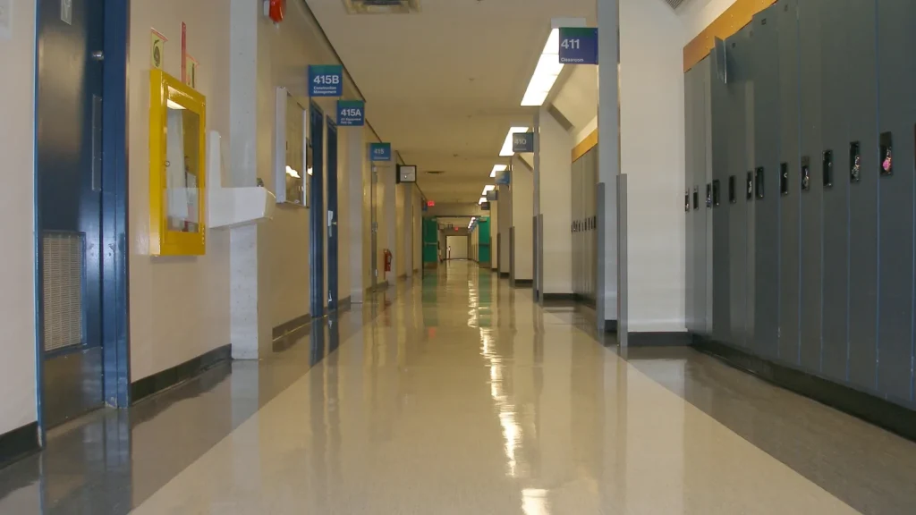 Couloir d'école vide bordé de casiers bleus avec un plancher luisant