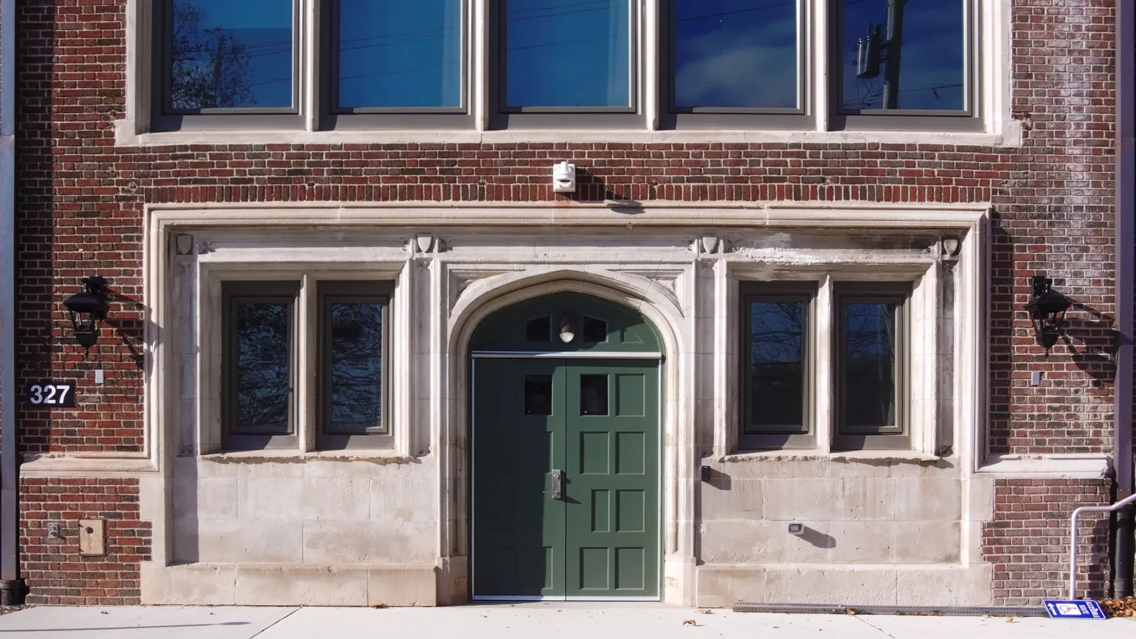 Façade d'une école primaire en briques avec porte d'entrée verte