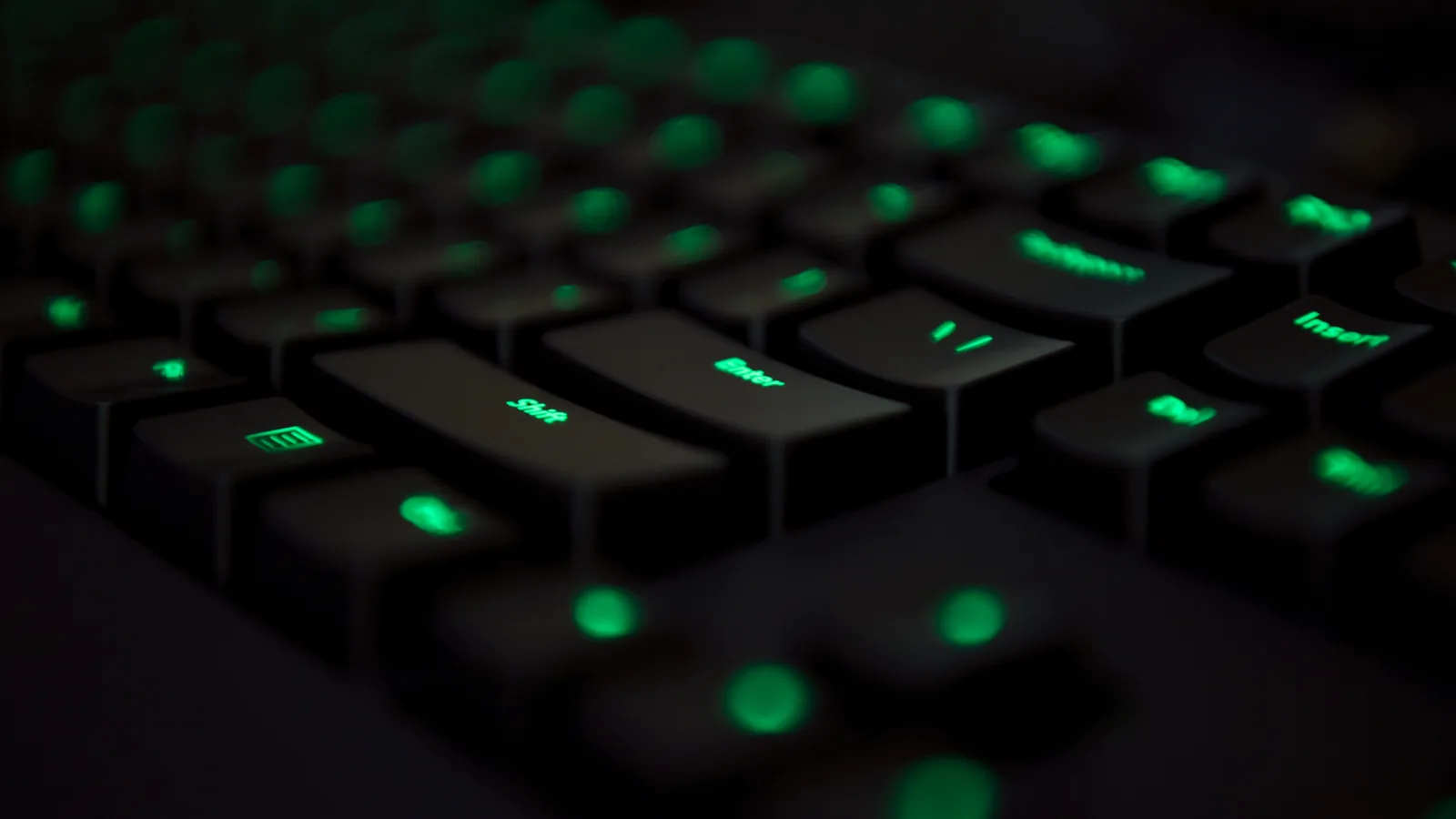Clavier d'ordinateur noir rétroéclairé en vert, en gros plan
