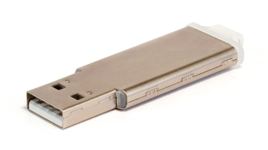 Clé USB métallique posée sur un fond blanc