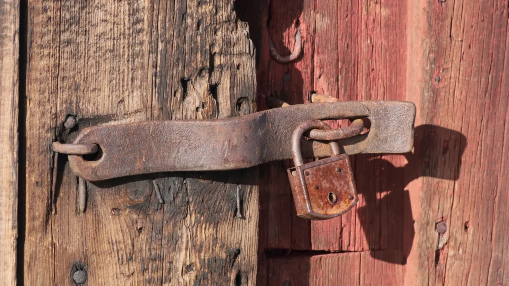 Cadenas rouillé sur une vieille porte de bois rouge