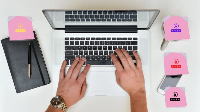 Mains sur un clavier d'ordinateur portable entouré de post-it roses avec des mots de passe